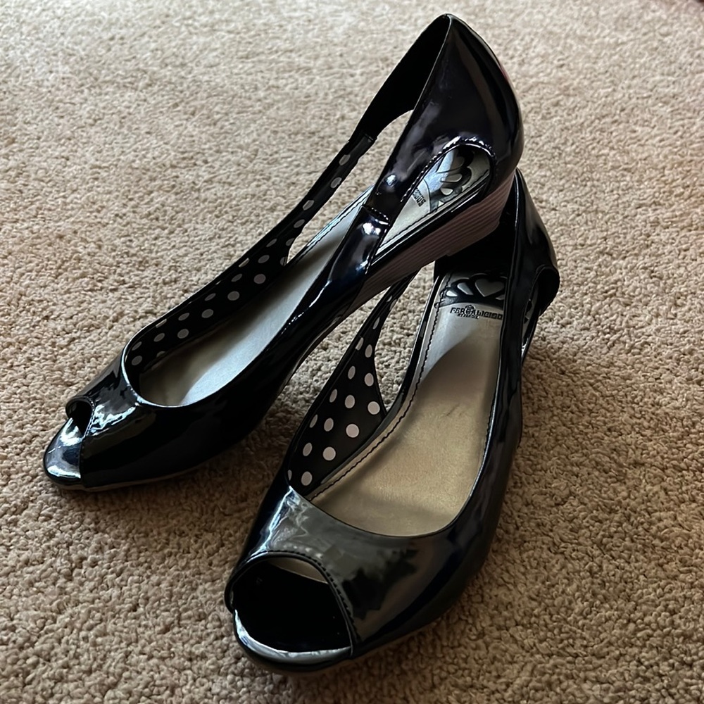 Fergalicious by Fergie
Size: 9M
Black patent leather peep-toe wedges